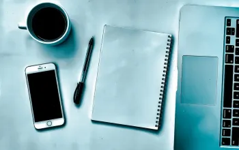 Laptop dan HP menampilkan halaman PDF yang sedang disusun menjadi satu dokumen